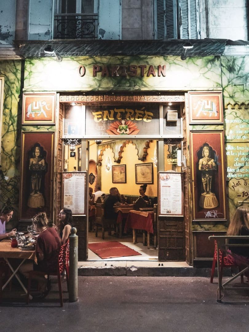 Façade de nuit du restaurant O'Pakistan, devanture peinte et terrasse rue des 3 Rois