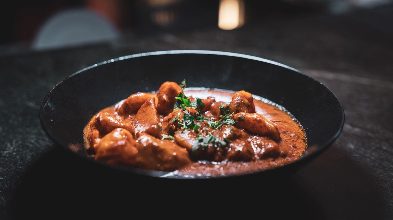 Butter Chicken en karahi de cuivre, sauce tomate crémeuse et coriandre fraîche