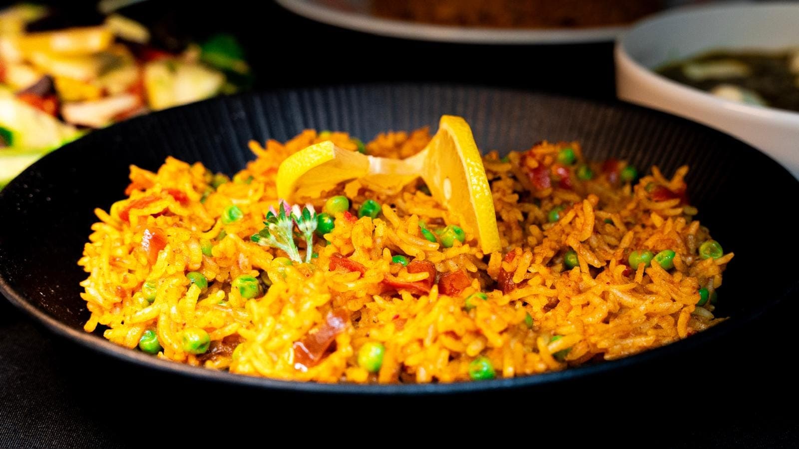 Riz basmati safrané aux petits pois et dés de tomate, servi avec un quartier de citron