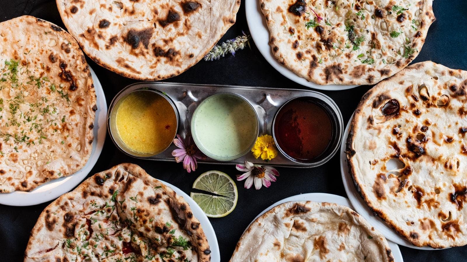 Nans dorés et gonflés tout juste sortis du tandoor, disposés autour de trois sauces